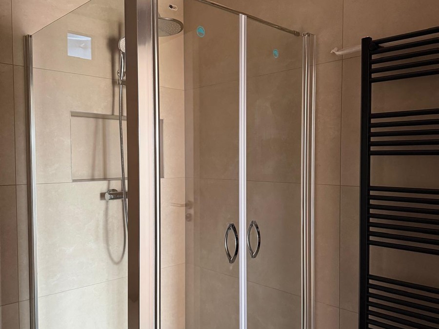 Dusche mit Kopfbrause und Handtuchheizkörper