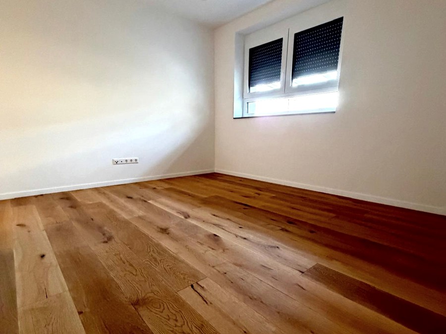 Schlafzimmer mit Eichenparkett und Fenster