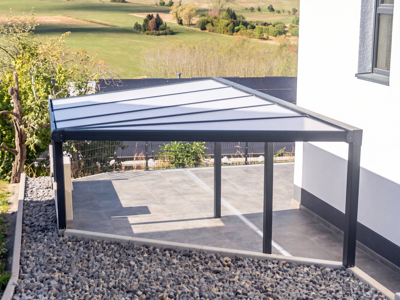 Überdachte Terrasse einer Wohnung im Untergeschoss mit lichtdurchlässigem Dach